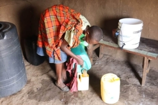 RipplAffect Samburu - woman in her home with bucket RipplAffect Samburu - woman in her home with bucket
