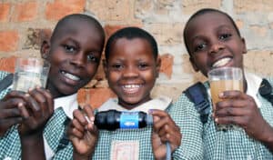 RipplAffect - Sawyer kids holding filter and clean dirty water