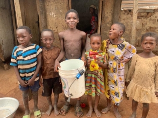 Ghana - group of kids with bucket smiling IMG_2121